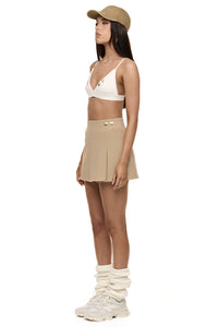 Semi side view of model wearing Formation Desert Xya Skirt with soft pleat and gold-toned buttons