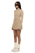 Semi side view of model wearing Formation Desert Xya Skirt with soft pleat and gold-toned buttons