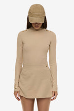 Close up of model wearing Formation Desert Xya Skirt with soft pleat and gold-toned buttons