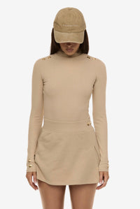 Close up of model wearing Formation Desert Xya Skirt with soft pleat and gold-toned buttons
