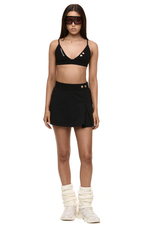 Model wearing Formation noir Xali bralette with logo embroidery and Xya Skirt in noir with soft pleat and gold-toned buttons
