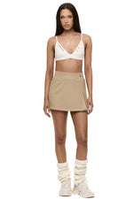 Model wearing Formation Xali bralette in ivory with embroidery logo and gold-toned buttons