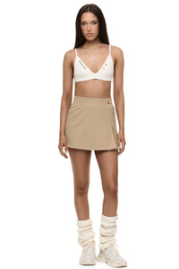 Model wearing Formation Xali bralette in ivory with embroidery logo and gold-toned buttons