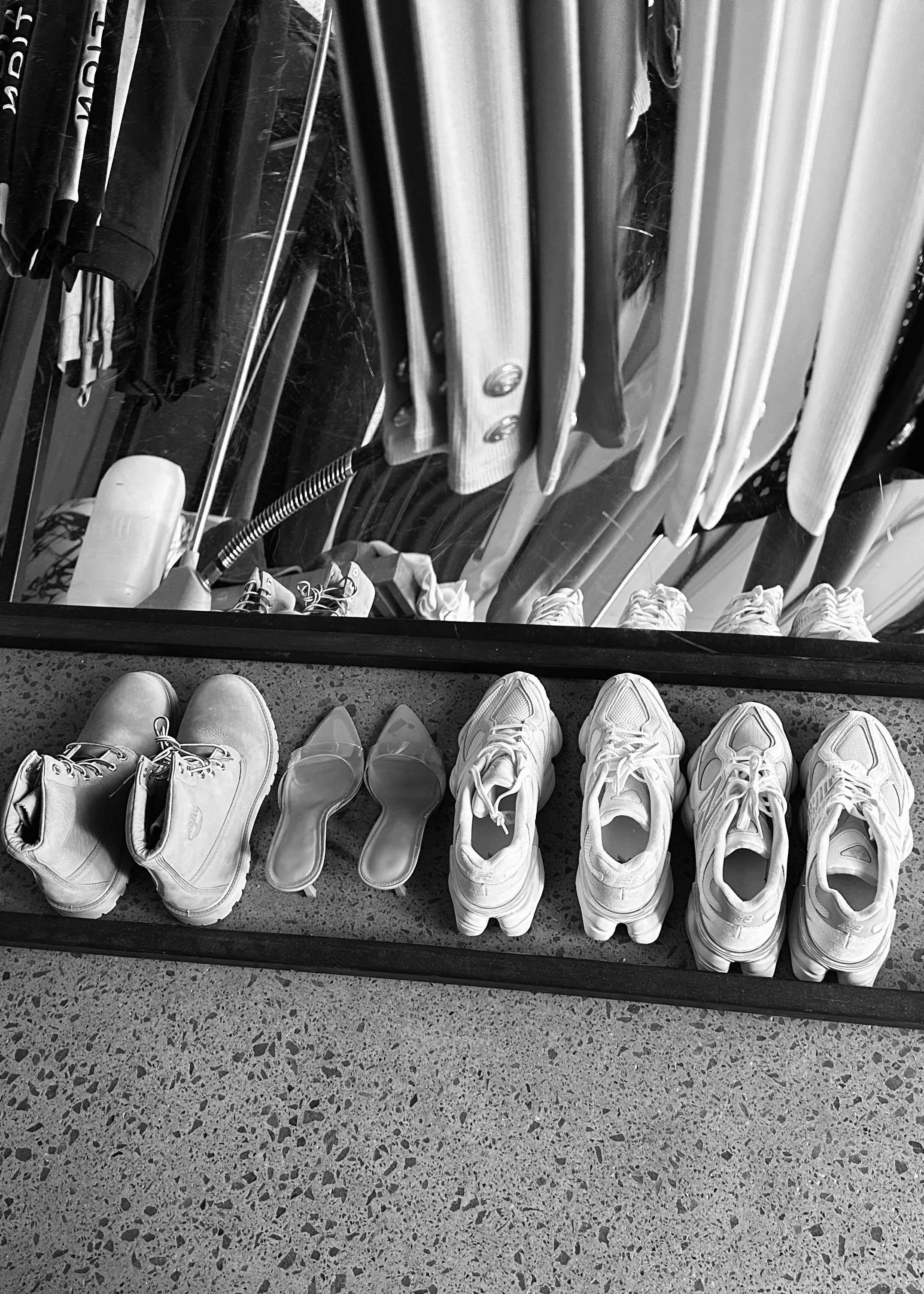 Black and white behind-the-scenes of a Formation shoot with wardrobe preparation
