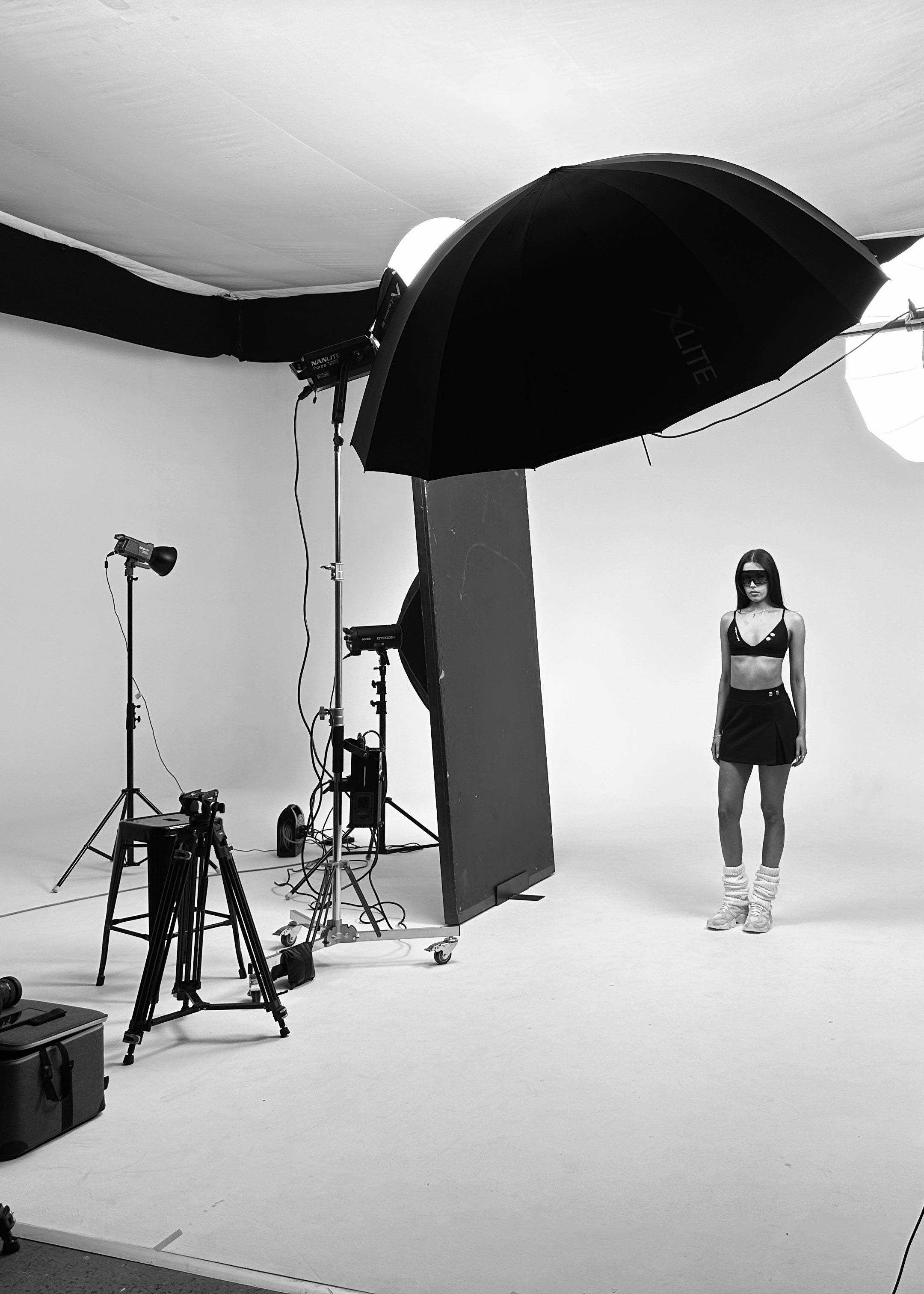 Black and white behind-the-scenes of a Formation shoot with model styling and set preparation
