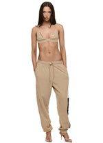 Model wearing Formation Xali Bralette in desert with embroidery logo and gold-toned buttons