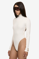 Close up of model wearing Formation Xaria bodysuit in ivory with gold-toned buttons