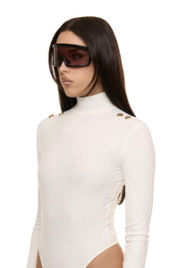 Close up of model wearing Formation Xaria bodysuit in ivory with gold-toned buttons
