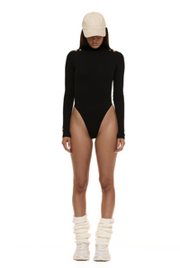 Model wearing Formation Xaria bodysuit in noir with gold-toned buttons