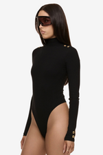 Close up of model wearing Formation Xaria bodysuit in noir with gold-toned buttons