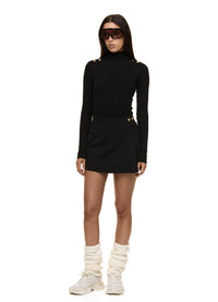 Model wearing Formation Xaria bodysuit in noir with gold-toned buttons