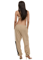 Back view of model wearing Formation Xion desert track pants with straight leg, noir and ivory side panels and embroidery logo